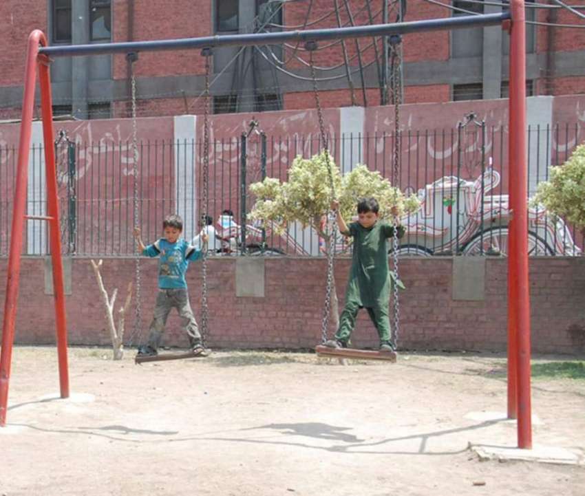 لاہور: مقامی پارک میں بچے دوپہر کے وقت شدید دھوپ میں جھولا ..
