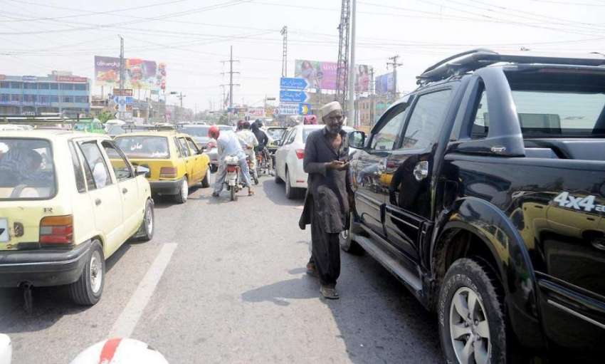 راولپنڈی: مری روڈ پر ٹریفک جام کے دوران ایک بھکاری بھیک مانگ ..