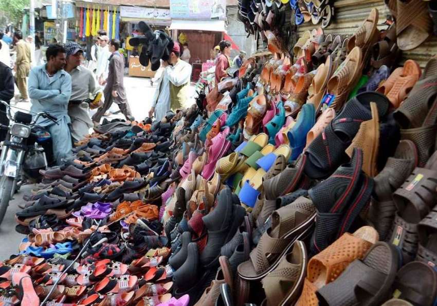 کوئٹہ: میزان چوک پر لگائے گئے اسٹال سے شہری چپلیں خرید رہے ..