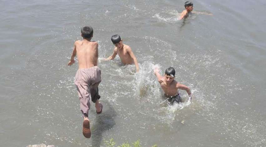 راولپنڈی: بچے گرمی کی شدت کم کرنے کے لیے نہر میں نہار ہے ہیں۔