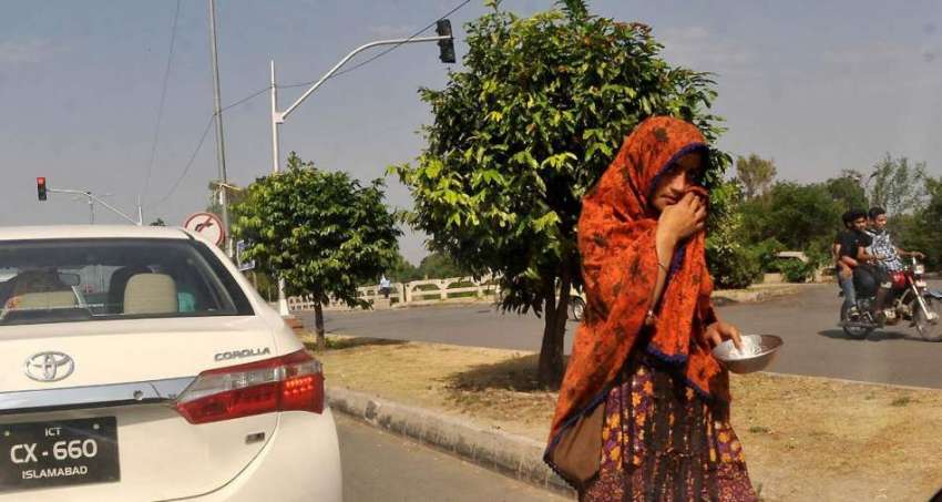 اسلام آباد: ایک خانہ بدوش خاتون سگنل پر کھڑی گاڑیوں سے بھیک ..