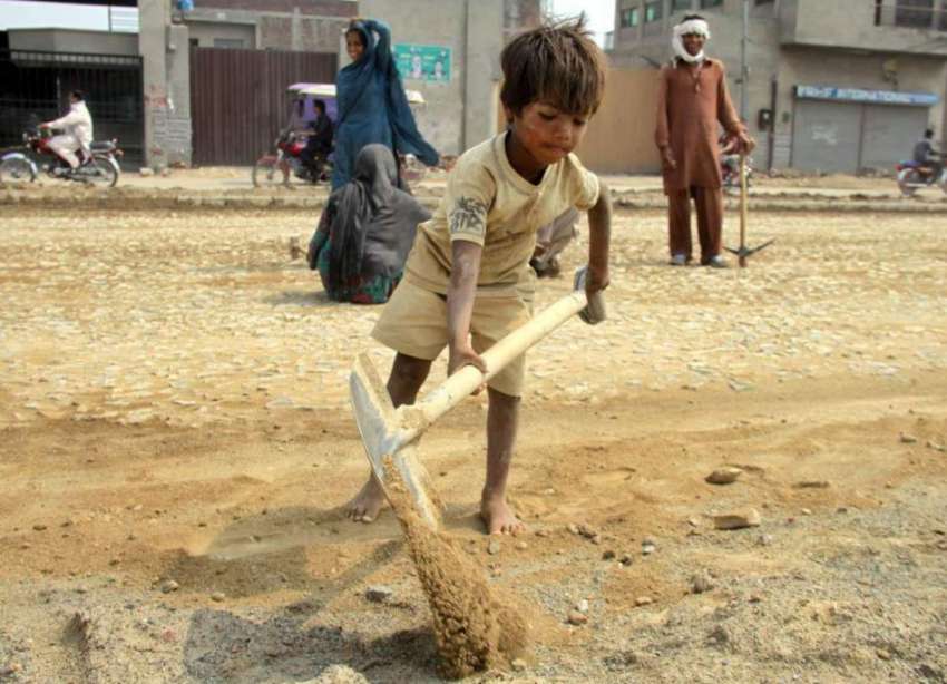 لاہور: ایک کمسن بچہ سڑک کے تعمیراتی کام میں اپنے والدین کے ..