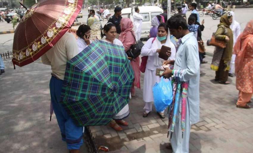 لاہور: محنت کش دھوپ سے بچنے کے لیے مال روڈ پر چھتریاں فروخت ..