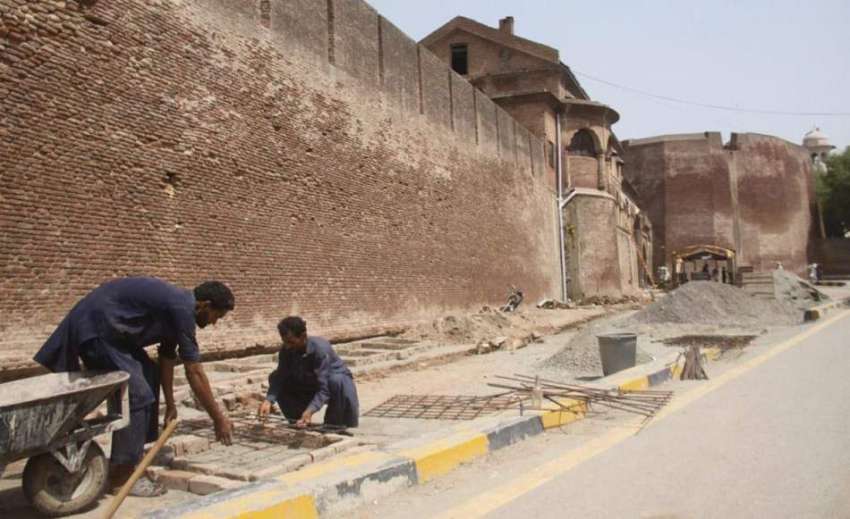 لاہور: تاریخی ورثہ شاہی قلعہ کی بیرونی دیوار کے ساتھ مزدور ..