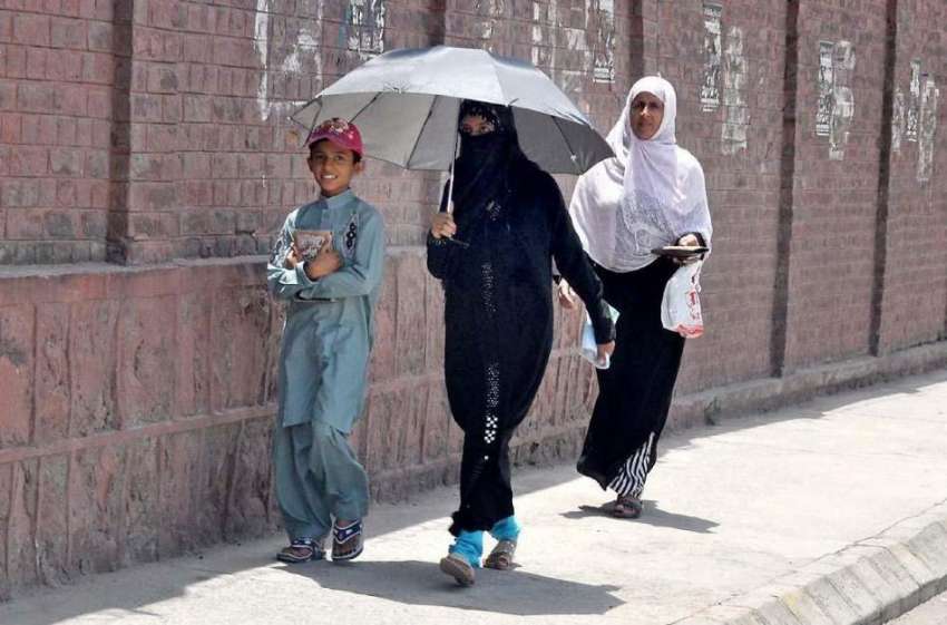 راولپنڈی: خواتین دھوپ سے بچنے کے لیے چھتری تھامے رواں دواں ..