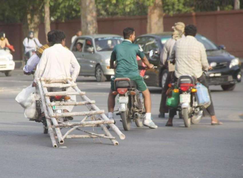 لاہور: موٹر سائیکل پر سوار دو محنت کش خطر ناک طریقے سے لکڑی ..