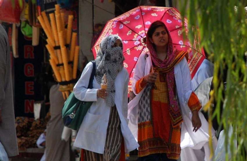 اسلام آباد: دھوپ کی شدت سے بچنے کے لیے خواتین چھتری تانے ..