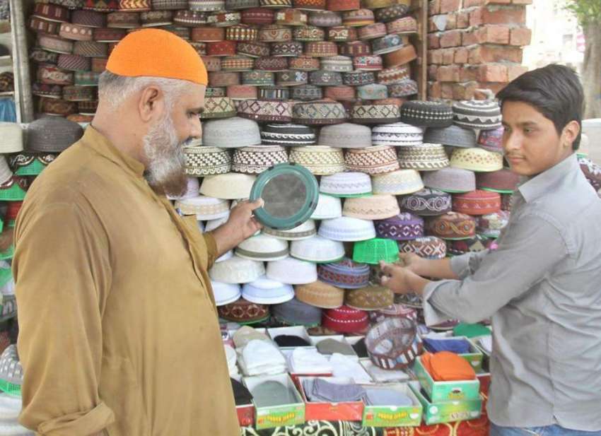 لاہور: رمضان المبارک کی مناسبت سے ایک نمازی ٹوپی پسند کر ..