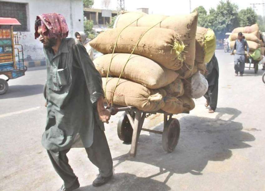 لاہور: ایک محنت کش شدید گرمی میں ہتھ ریڑھی پر بھاری سامان ..