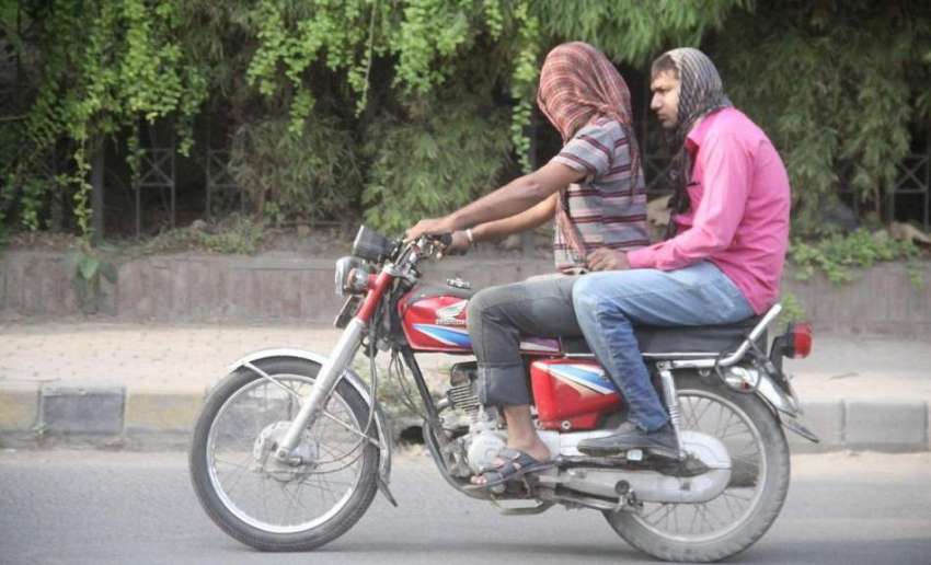 لاہور: گرمی کی شدت سے بچنے کے لیے موٹر سائیکل سوار رومال ..