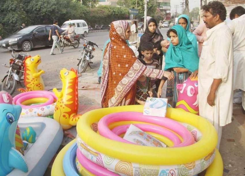 لاہور: خواتین سڑک کنارے فروخت کے لیے رکھے چھوٹے سوئمنگ پول ..