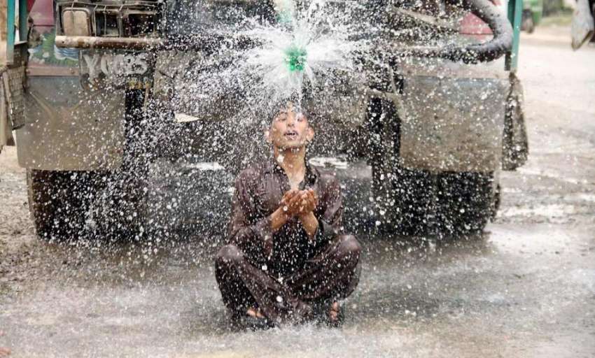 لاہور: گرمی کی شدت کم کرنے کے لیے ایک نوجوان نہا رہا ہے۔