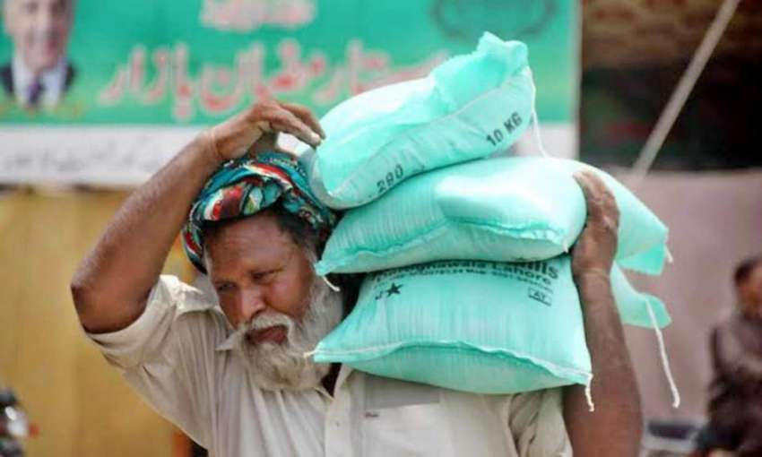 لاہور: باغبانپورہ رمضان بازار سے ایک شخص آٹے کے تھیلے خرید ..