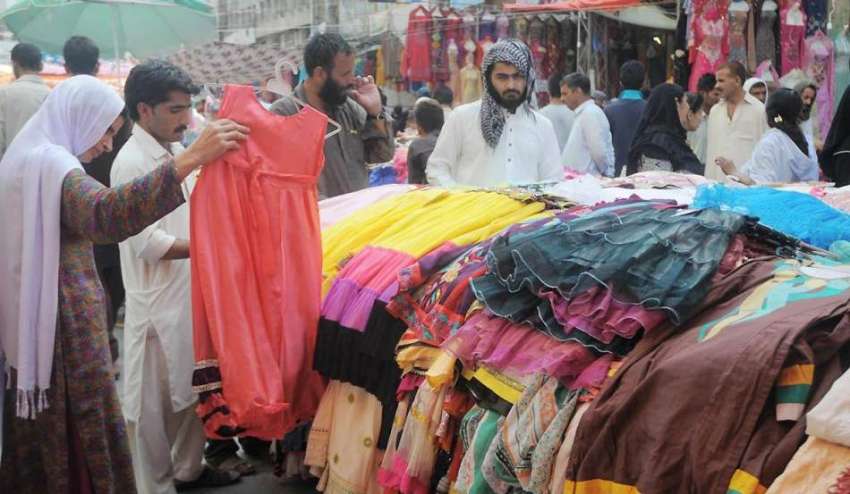 راولپنڈی: راجہ بازار میں ایک خاتون بچوں کے کپڑے پسند کر رہی ..