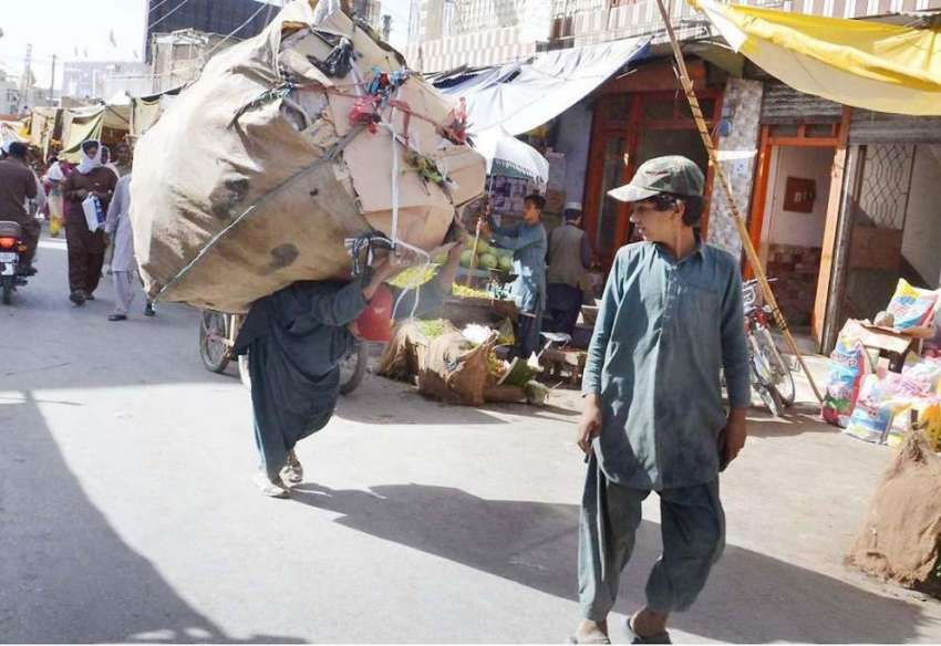 کوئٹہ: ایک کمر عمر لڑکا بھاری سامان اٹھائے سبزی مارکیٹ سے ..