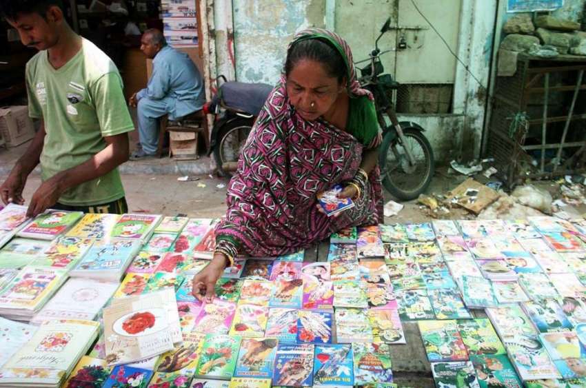 کراچی: خاتون سڑک کنارے سجے سٹال سے عید کارڈ خرید رہی ہے۔