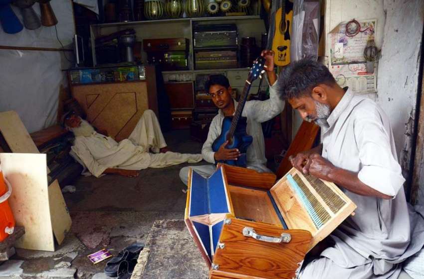 لاہور: محنت کش اپنی ورکشاپ میں موسیقی کے آلات تیار کر رہے ..
