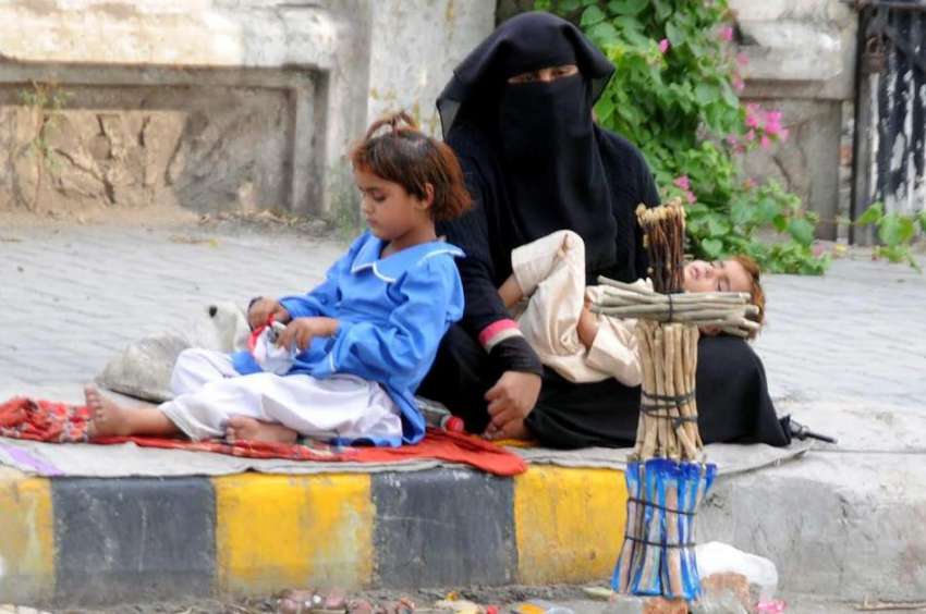 راولپنڈی:ایک خاتون اپنے دو کمسن بچوں کے ہمراہ سڑک کنارے ..