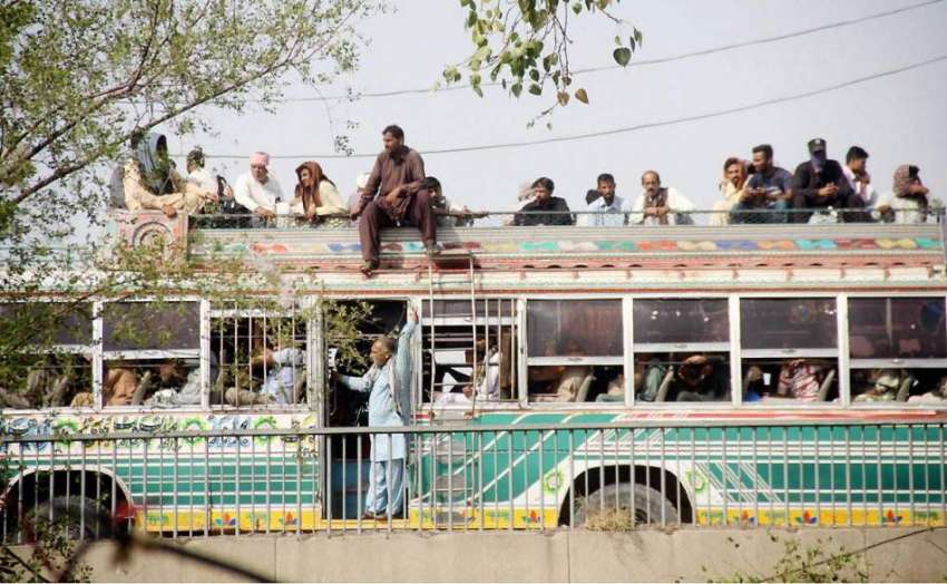 لاہور: ٹرانسپورٹ کی کمی کے باعث شہری بس کی چھت پر سوار ہو ..
