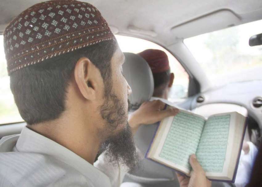 لاہور: ایک روزہ دار دوران سفر قرآن پاک کی تلاوت کر رہا ہے۔