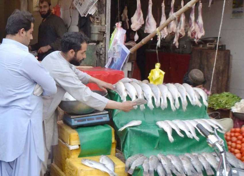 کوئٹہ: سبزی مارکیٹ میں ایک دوکاندار گاہک کو مچھلی فروخت ..
