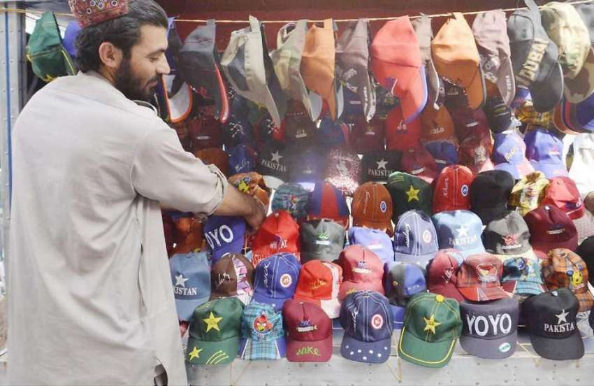 کوئٹہ: لیاقت بازار میں ایک دوکاندار ٹوپیاں سجا رہا ہے۔