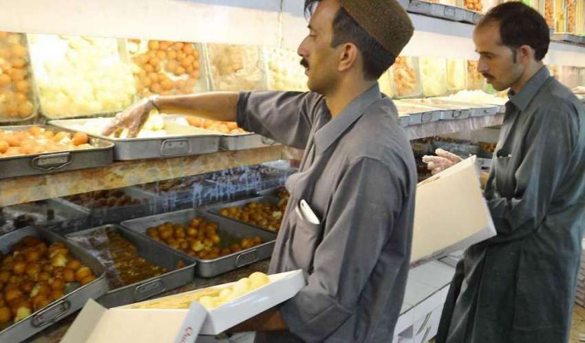 کوئٹہ: عیدالفطر کے لیے ایک سویٹ ہاؤس میں دوکاندار مٹھائیاں ..