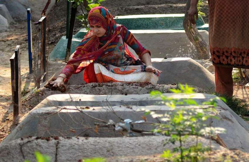 لاہور: عید الفطر کی آمد کے موقع پر قبرستان میں خاتون اپنے ..