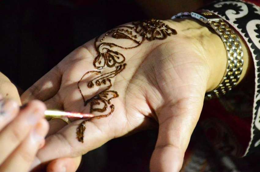 فیصل آباد: ایک خاتون عیدالفطر کی آمد کے موقع پر ہاتھوں پر ..