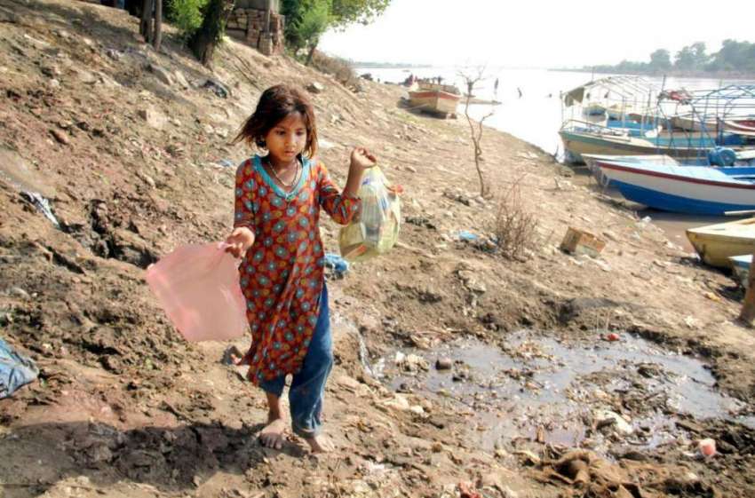 لاہور: ایک خانہ بدوش بچی دریائے راوی کے کنارے کچرا اٹھائے ..