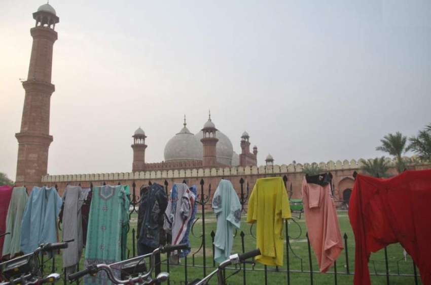 لاہور: مقامی لوگوں نے بادشاہی مسجد کے جنگلے پر خشک کرنے کے ..