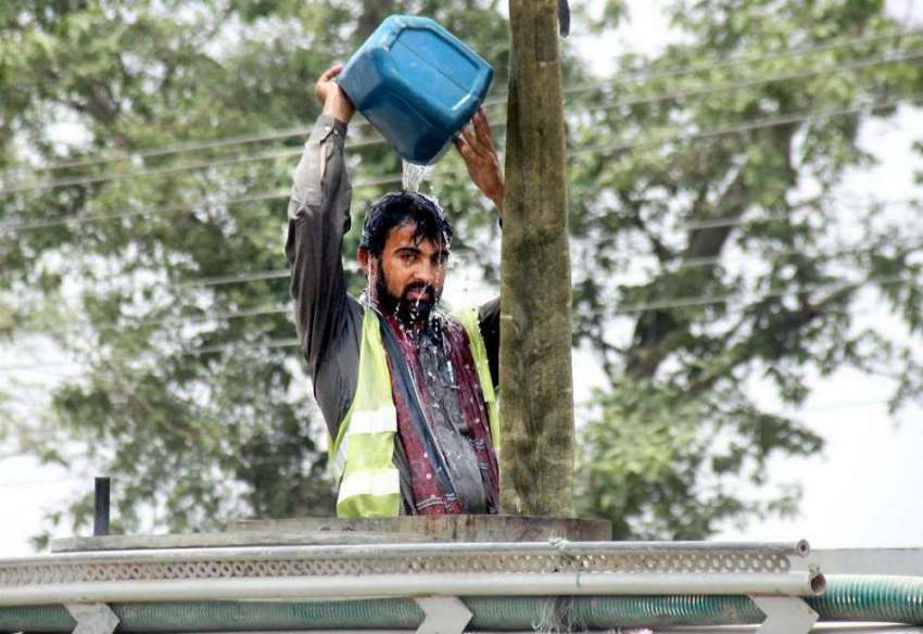 لاہور: گرمی کی شدت کم کرنے کے لیے ایک محنت کش نہا رہا ہے۔