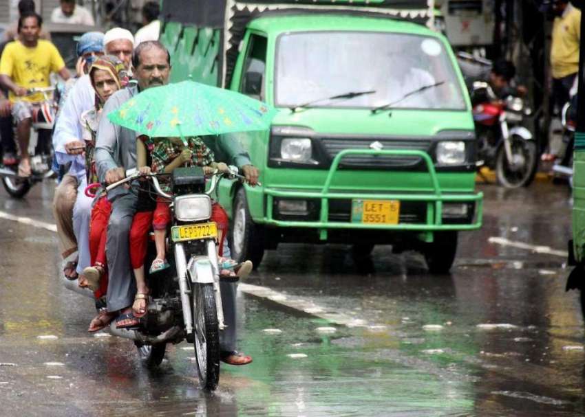 لاہور: صوبائی دارالحکومت میں بارش کے دوران موٹر سائیکل پر ..