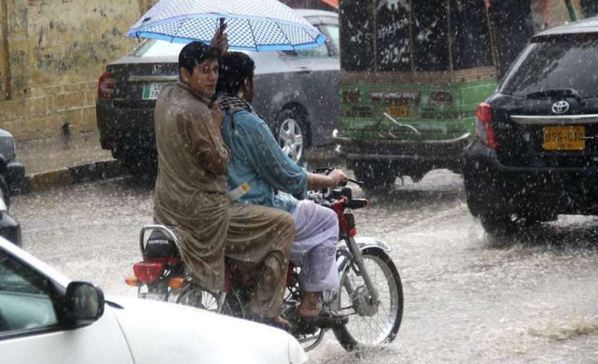 لاہور: صوبائی دارالحکومت میں بارش کے دوران موٹر سائیکل سوار ..