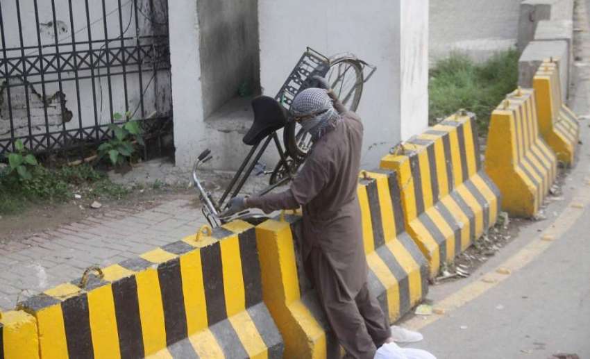 لاہور: مال روڈ دھرنے کے باعث سڑک بند پر ایک شخص سائیکل اٹھائے ..