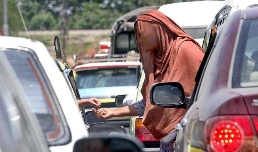 راولپنڈی: ایک خاتون ٹریفک سگنل بند پر کھڑی گاڑیوں کے سواروں ..