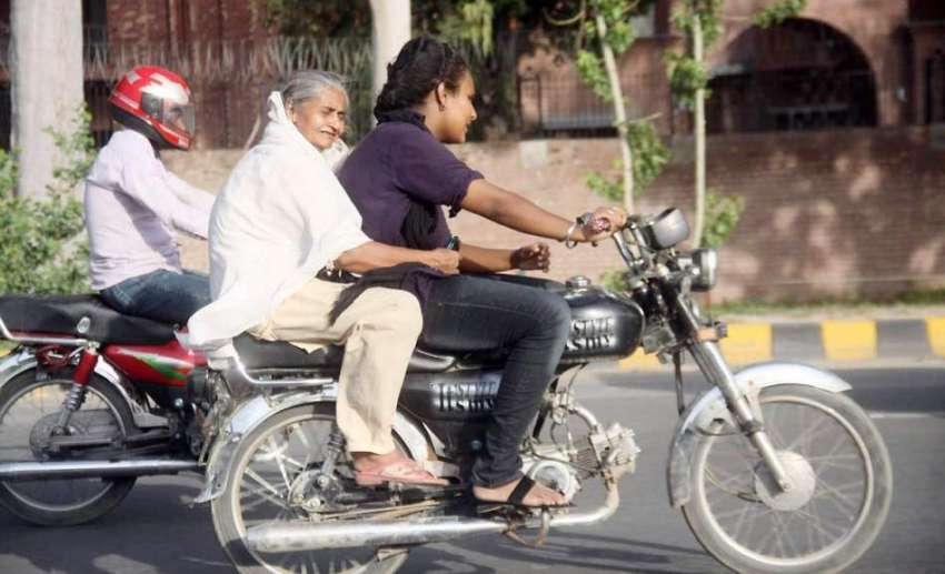 لاہور: کنال روڈ پر ایک موٹر سائیکل سوار لڑکی اپنی دادی کو ..