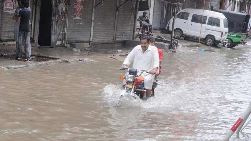 راولپنڈی:موٹر سائیکل سوار بارش کے جمع شدہ پانی سے گزر رہا ..