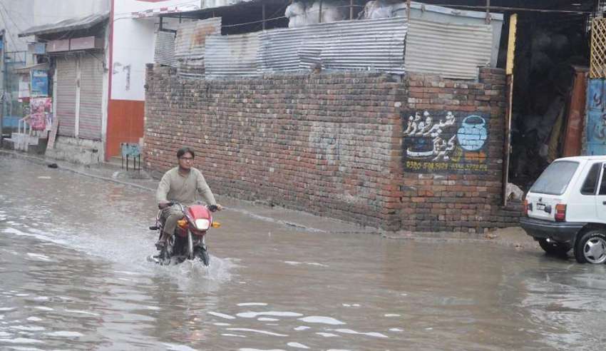 راولپنڈی:موٹر سائیکل سوار بارش کے جمع شدہ پانی سے گزر رہا ..