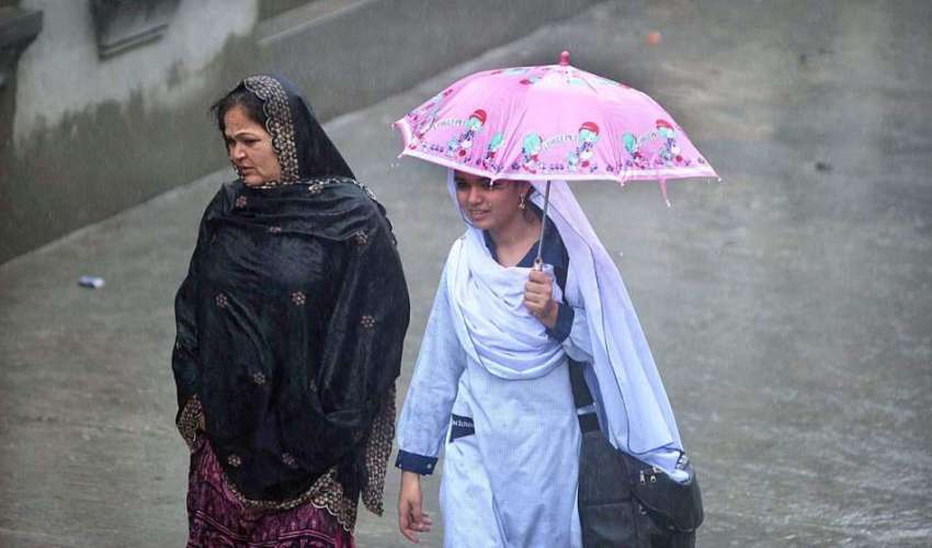 راولپنڈی:بارش کے دوران ایک طالبہ چھتری تانے جا رہی ہے۔