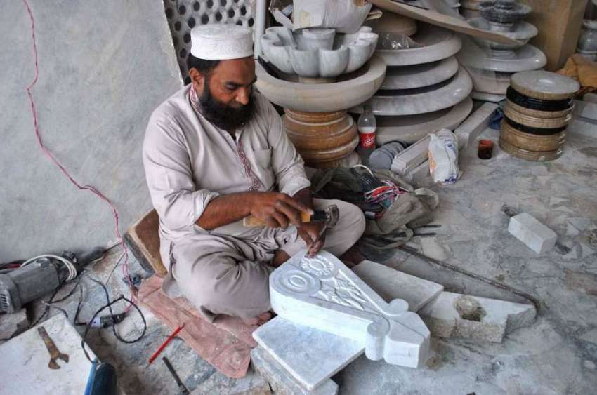 لاہور: ایک محنت کش پتھر کی بناؤ سنگھار کے کام میں مصروف ہے۔