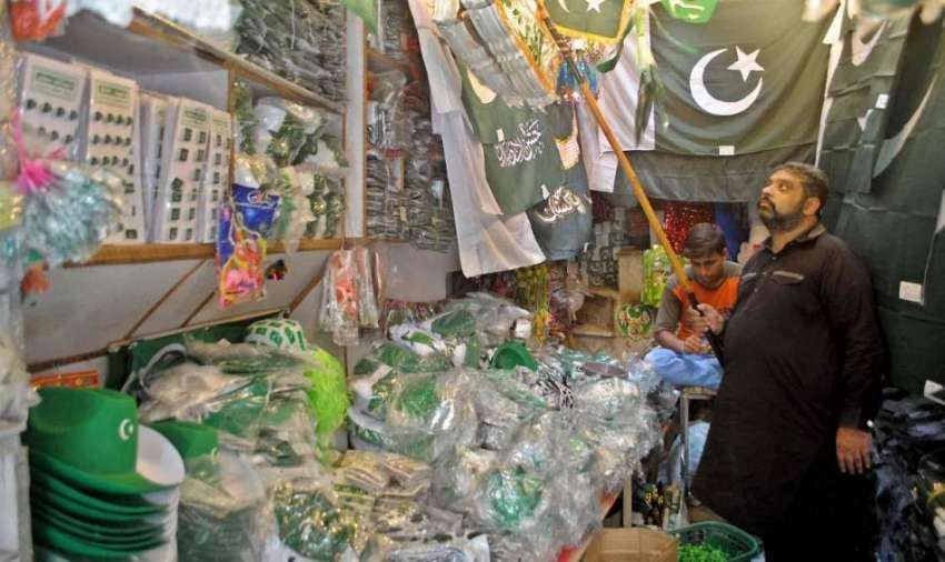 راولپنڈی: ایک محنت کش اپنی دوکان پر جشن آزادی کی آمد کی مناسبت ..