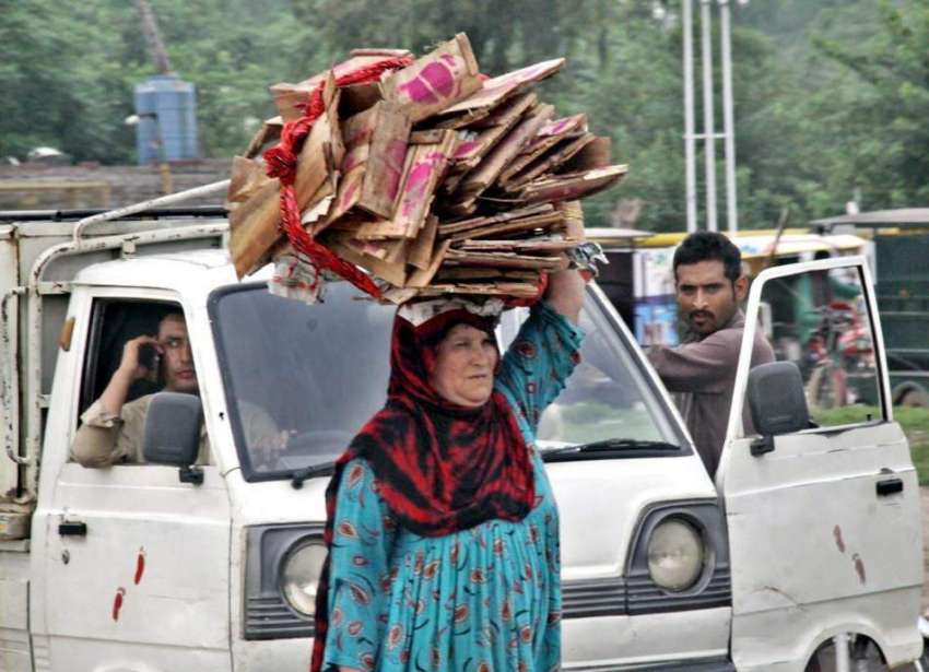 لاہور: ایک خاتون گھر کا چولہا جلانے کے لیے لکڑیاں سر پر اٹھا ..