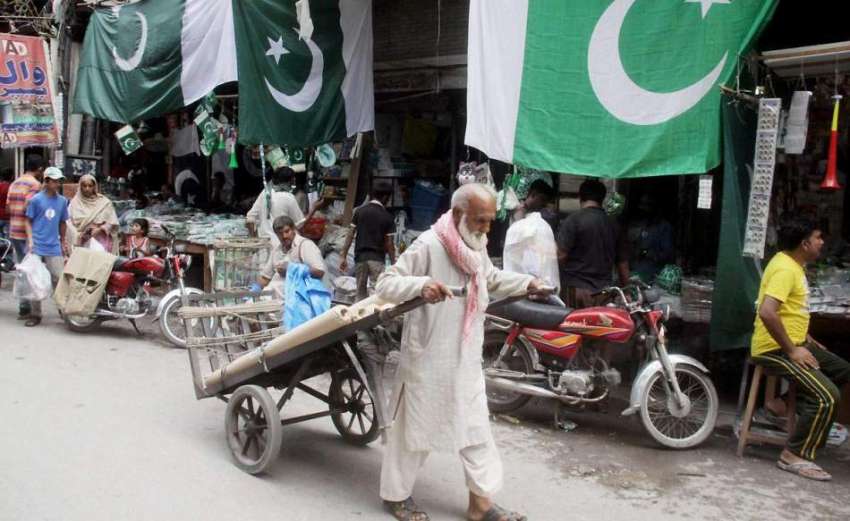 لاہور: ایک بزرگ محنت کش ہتھ ریڑھی پر سامان رکھے جا رہا ہے۔