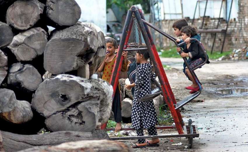 راولپنڈی: لکڑی کے ٹال کے قریب پڑے جھولے سے بچے لطف اندوز ..