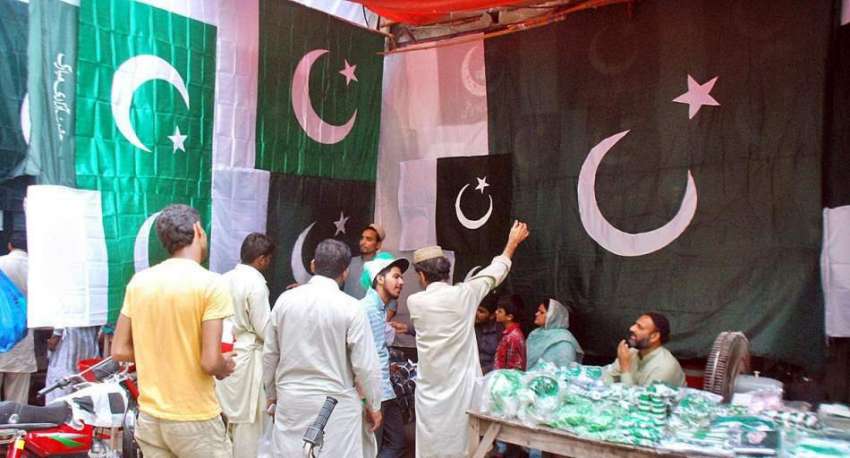 لاہور: ایک دوکان دار نے جشن آزادی کے سلسلے میں قومی پرچم ..