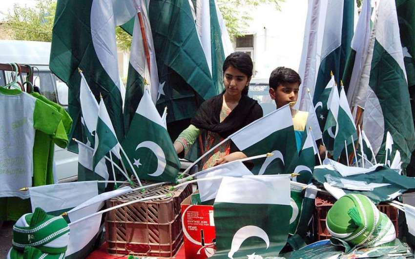 اسلام آباد: جشن آزادی کی آمد کے موقع پر دو بچے ایک سٹال سے ..
