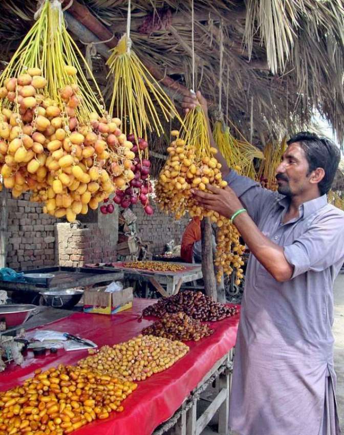 فیصل آباد: دوکاندار اپنے دوکان میں تازہ کھجوریں فروخت کے ..