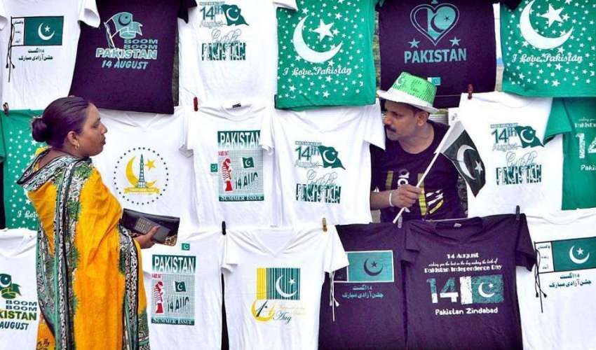 لاہور: ایک دکاندار نے روڈ کنارے قومی پرچم والی ٹی شرٹس فروخت ..