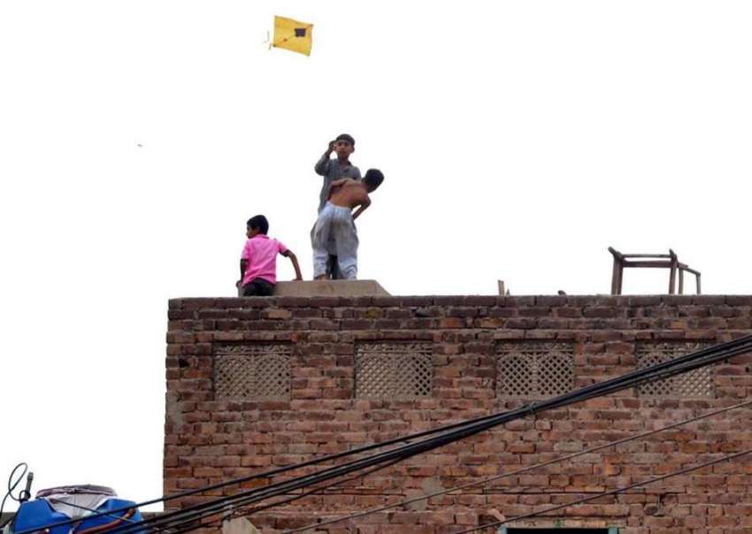 ملتان: بچے ایک عمارت کی چھت کے اوپر والے حصے پر پتنگ اڑا رہے ..